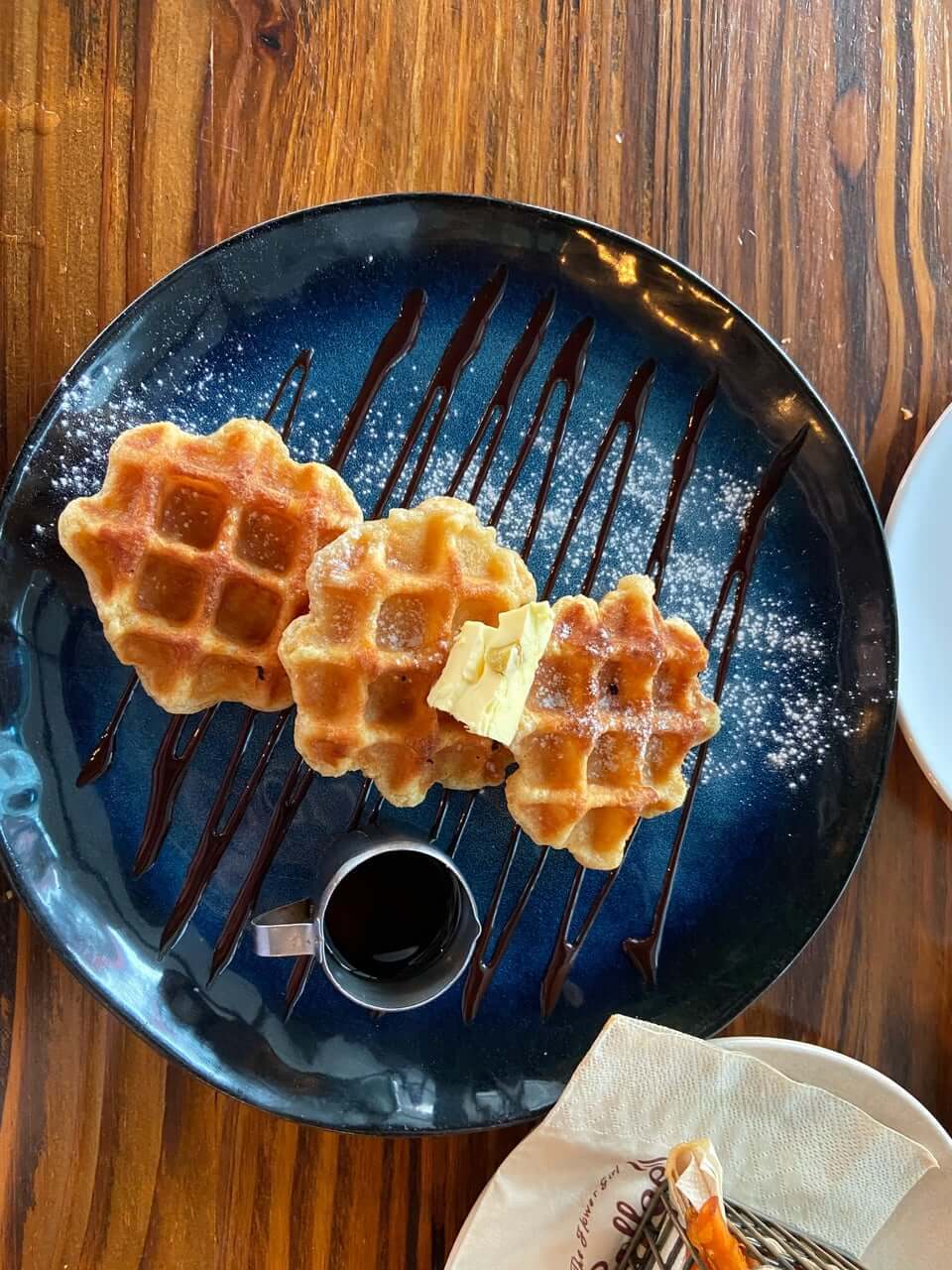 Three simple waffles drizzled with apricot butter and maple syrup – perfect for those looking for a light dessert at Flower Girl Coffee
